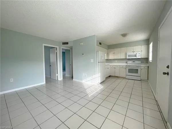 a large white kitchen with white cabinets