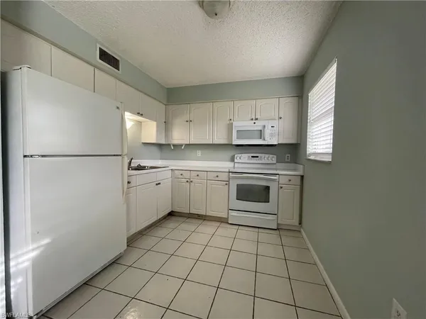 a kitchen with white cabinets stainless steel appliances and a sink