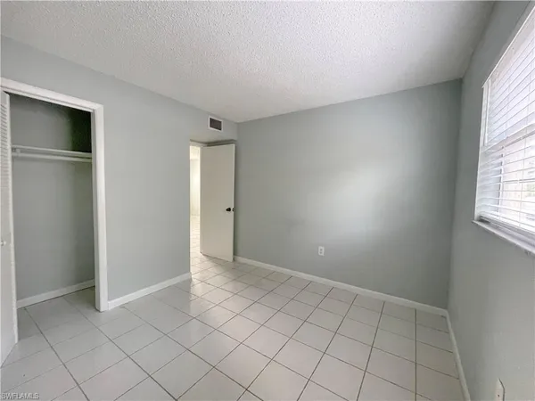 an empty room with windows and closet