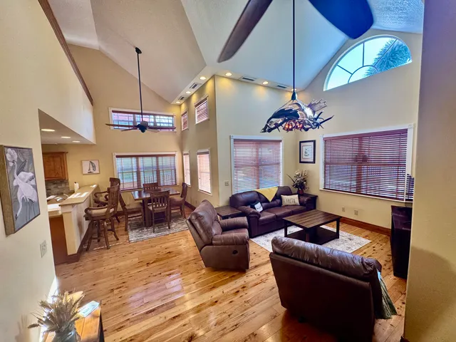 a living room with furniture a chandelier and a flat screen tv