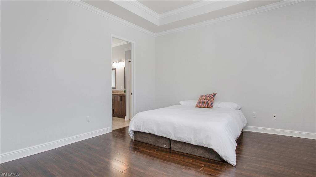 6341 Green Boulevard Naples, FL 34116 - Photo 13 of 48 a bedroom with a bed and wooden floor