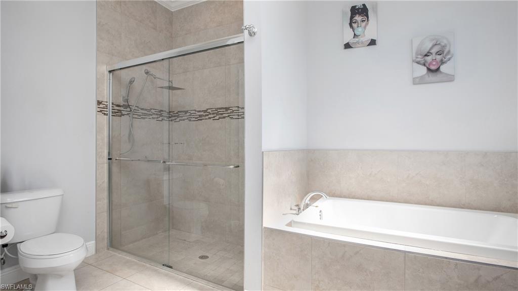 6341 Green Boulevard Naples, FL 34116 - Photo 16 of 48 a bathroom with a bathtub and a shower