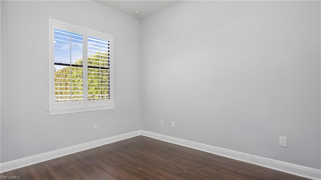6341 Green Boulevard Naples, FL 34116 - Photo 18 of 48 a view of an empty room with wooden floor and a window