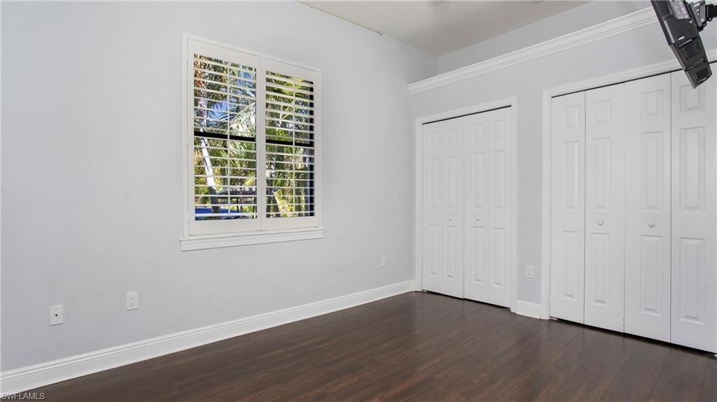 6341 Green Boulevard Naples, FL 34116 - Photo 19 of 48 a view of an empty room with wooden floor and a window