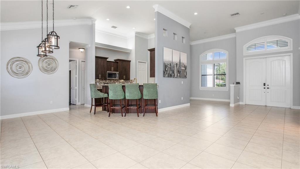 6341 Green Boulevard Naples, FL 34116 - Photo 23 of 48 Entryway with light tile patterned floors, crown molding, baseboards, a high ceiling, and recessed lighting