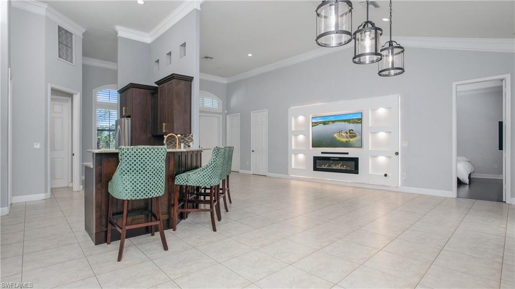 6341 Green Boulevard Naples, FL 34116 - Photo 26 of 48 a view of a a dining room with furniture wooden floor and a chandelier