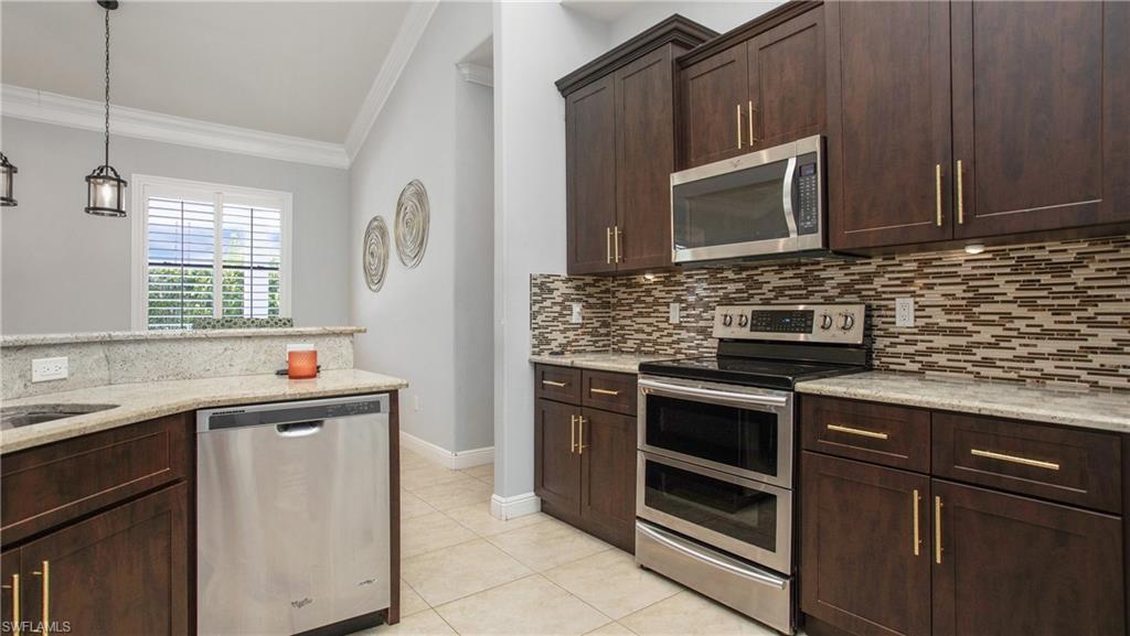 6341 Green Boulevard Naples, FL 34116 - Photo 30 of 48 a kitchen with a stove microwave and sink