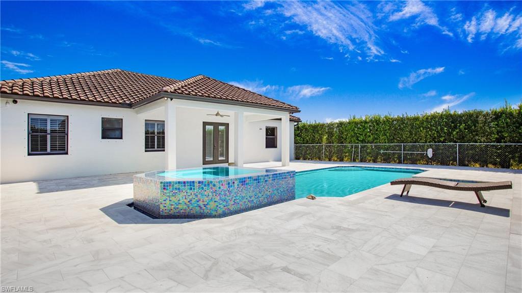 6341 Green Boulevard Naples, FL 34116 - Photo 34 of 48 View of swimming pool with a patio, fence, a ceiling fan, french doors, and a pool with connected hot tub