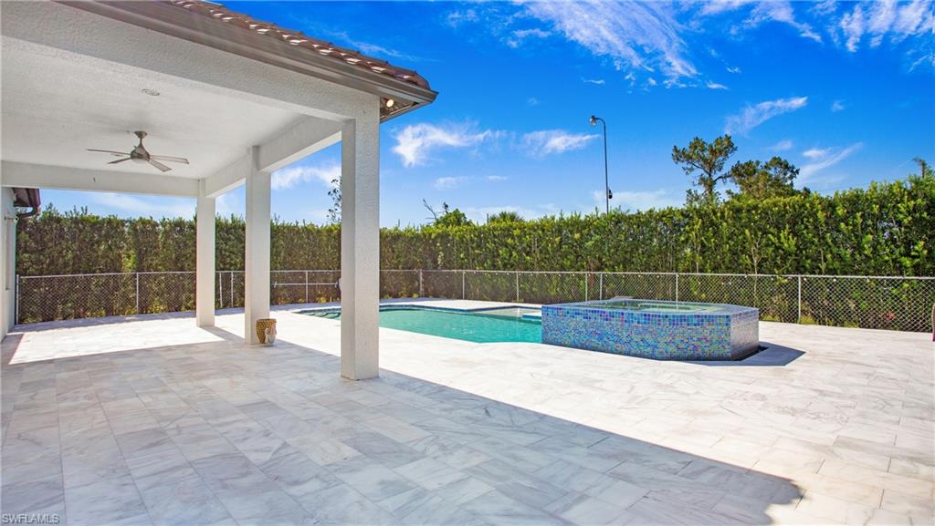 6341 Green Boulevard Naples, FL 34116 - Photo 35 of 48 View of pool featuring ceiling fan, a patio, a fenced backyard, and a pool with connected hot tub