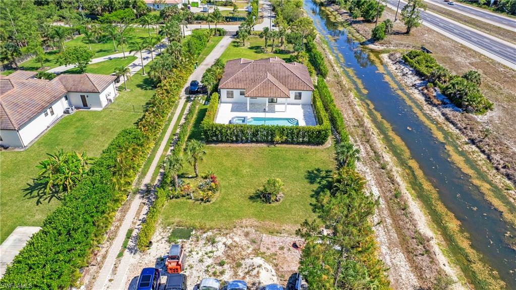 6341 Green Boulevard Naples, FL 34116 - Photo 44 of 48 View from above of property with a pool area and a nearby body of water