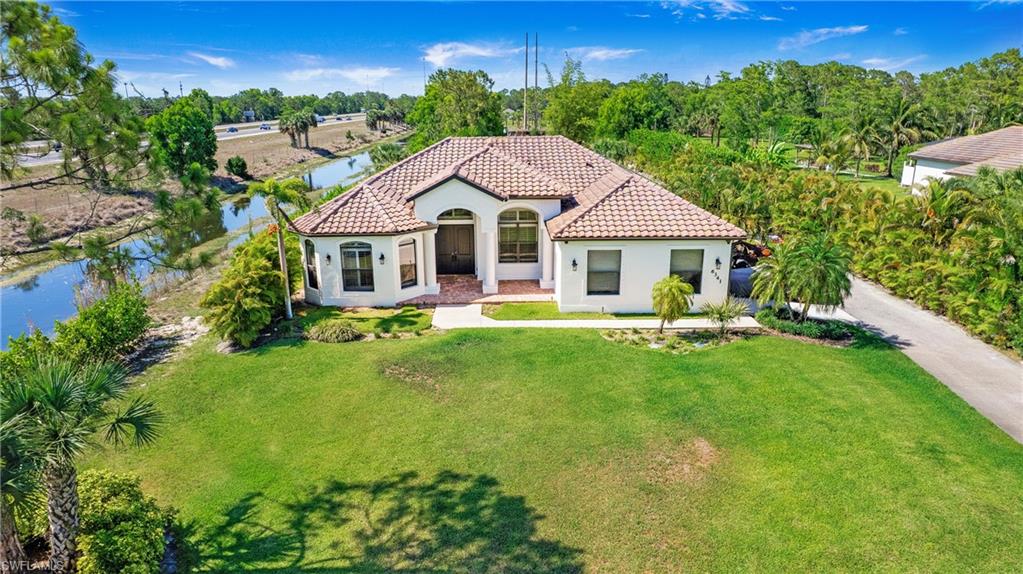 6341 Green Boulevard Naples, FL 34116 - Photo 5 of 48 a front view of a house with a yard