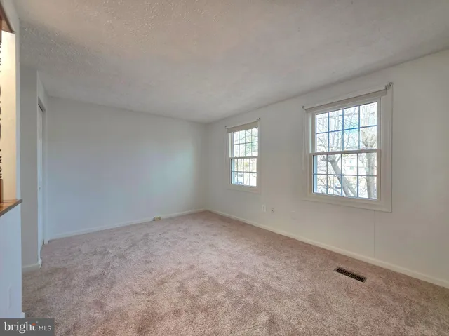a view of a big room with windows and chandelier