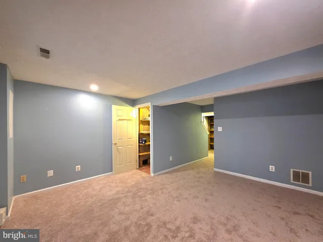 a view of a big room with windows and chandelier