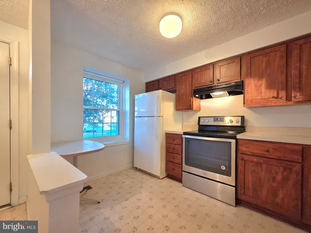 a kitchen with stainless steel appliances granite countertop a refrigerator stove and sink