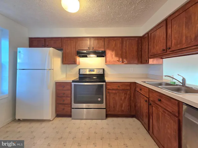 a kitchen with a refrigerator sink and cabinets