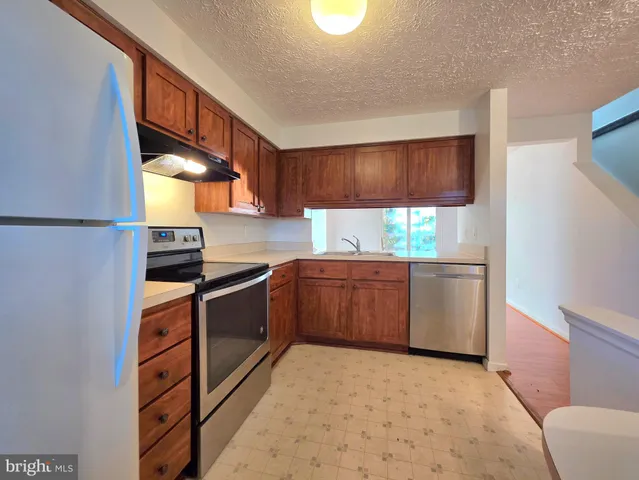 a kitchen with stainless steel appliances a stove a sink and a refrigerator
