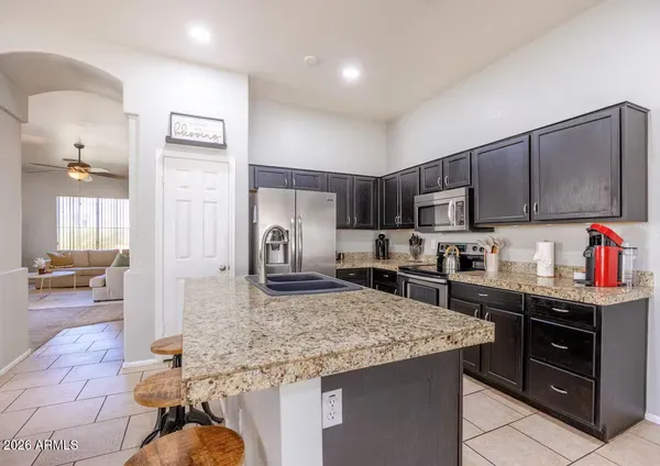 a kitchen with stainless steel appliances granite countertop a stove refrigerator and sink