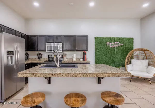 a kitchen with stainless steel appliances granite countertop a sink a stove and a refrigerator