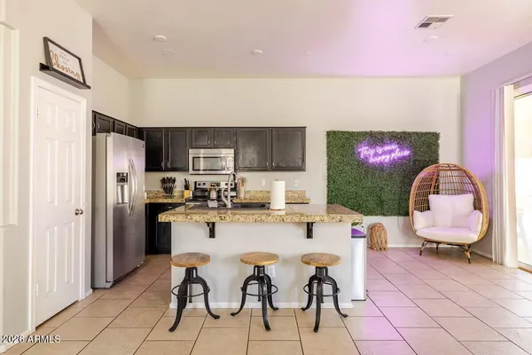 a kitchen with stainless steel appliances kitchen island granite countertop a refrigerator and a stove top oven