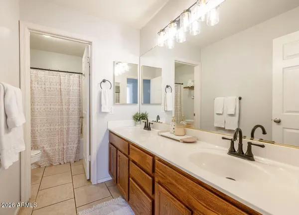 a bathroom with a double vanity sink mirror and shower