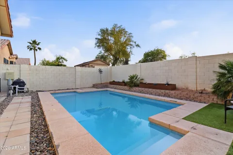 swimming pool view with plants and large trees