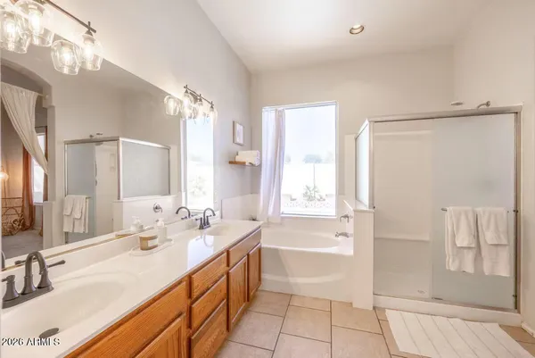 a spacious bathroom with a bathtub shower sink and mirror