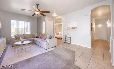 a living room with furniture and a ceiling fan