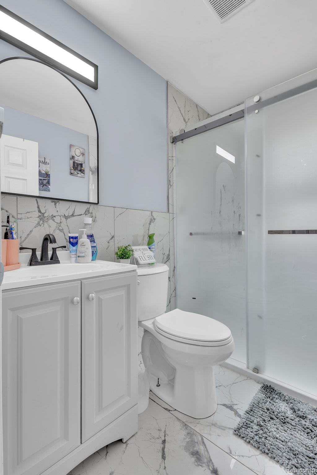 8401 Fielding Street Detroit, MI 48228 - Photo 12 of 34 Full bathroom with a shower stall, vanity, and tile walls
