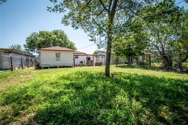 a view of a house with backyard and tree