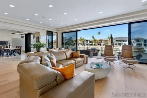 a living room with furniture kitchen view and large windows
