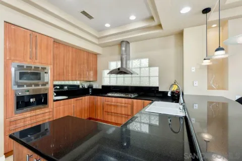 a kitchen with stainless steel appliances granite countertop a stove a sink and a microwave