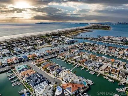 an aerial view of a city with lots of residential buildings ocean and mountain view in back