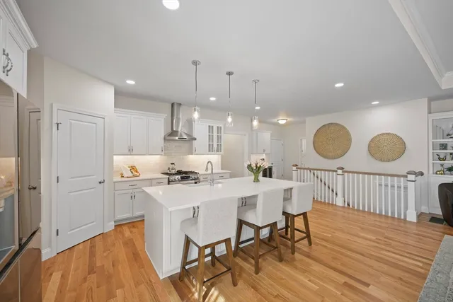 a kitchen with a table chairs stove a refrigerator and cabinets
