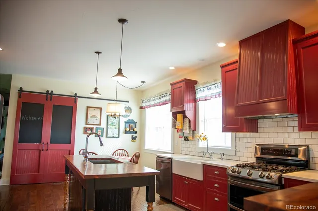 a kitchen with granite countertop a sink a stove and wooden cabinets