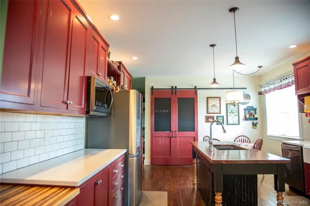 a kitchen that has a table chairs in it and wooden cabinets
