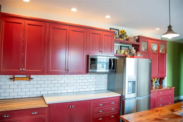a kitchen with stainless steel appliances granite countertop a refrigerator and a stove top oven