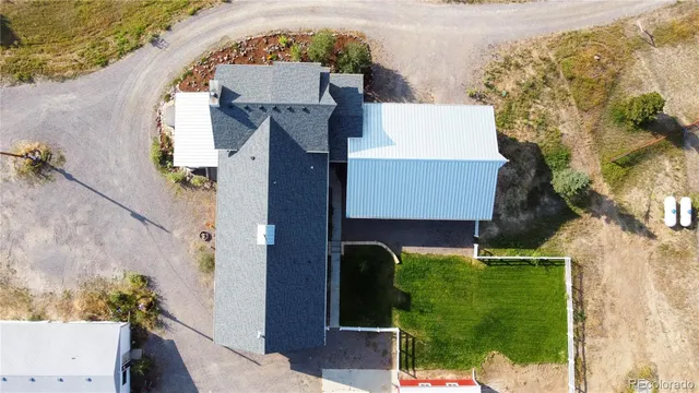 an aerial view of a house with a yard and seating space