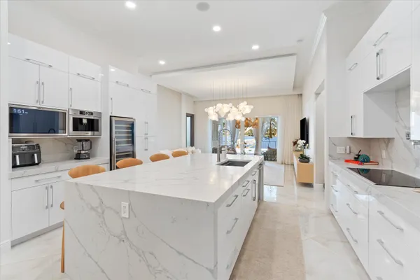 a large white kitchen with stainless steel appliances and white cabinets