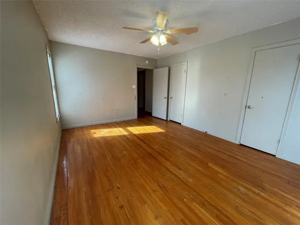 a view of a big room with wooden floor and a chandelier fan