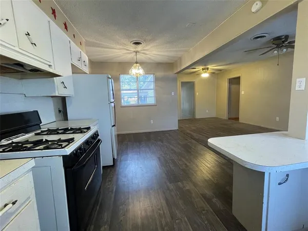 a kitchen with stove and cabinets