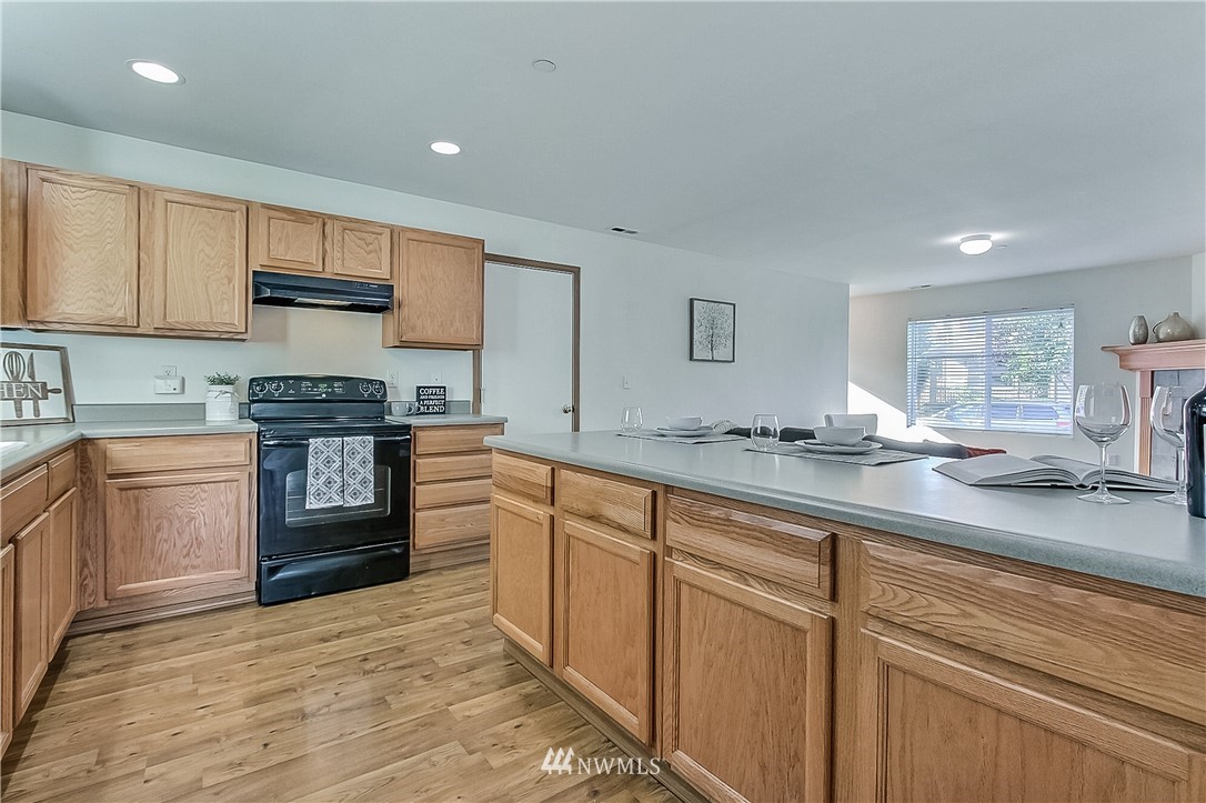 3075 Walker Road DuPont, WA 98327 - Photo 7 of 27 a kitchen with stainless steel appliances granite countertop a sink stove and refrigerator