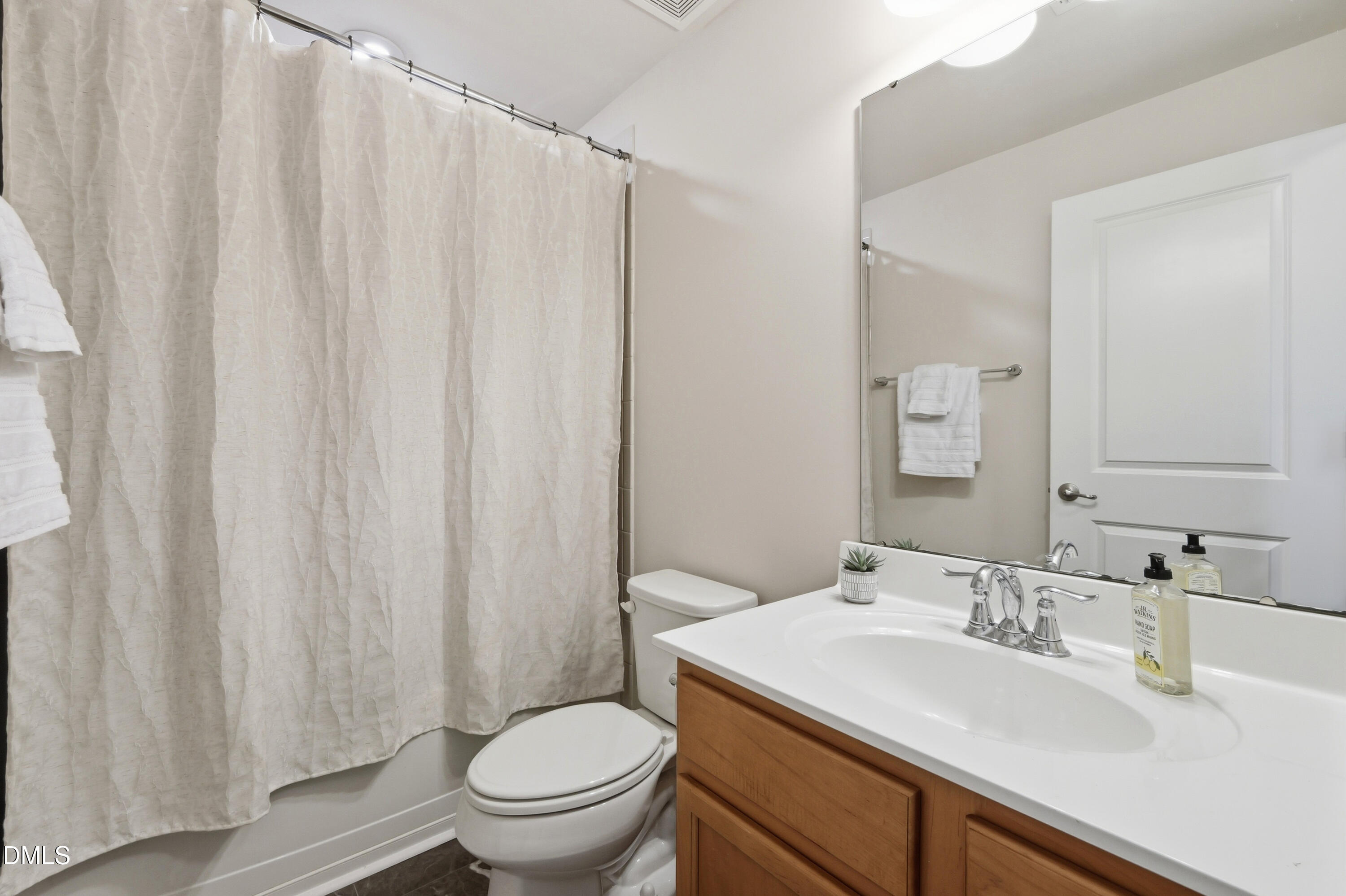 1004 Waymaker Court Apex, NC 27502 - Photo 27 of 30 a bathroom with a sink a toilet and shower curtain
