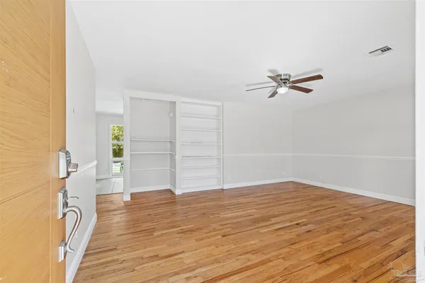 a view of empty room with wooden floor