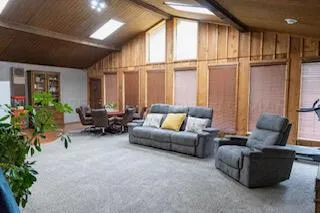 a living room with furniture kitchen view and a large window
