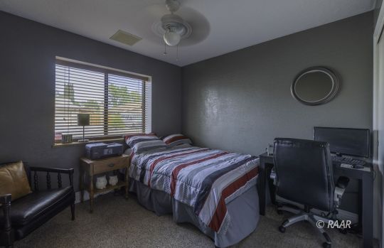 815 James Street Ridgecrest, CA 93555 - Photo 16 of 27 a bedroom with a bed and a chair