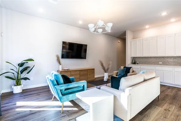 a living room with furniture a potted plant and a flat screen tv