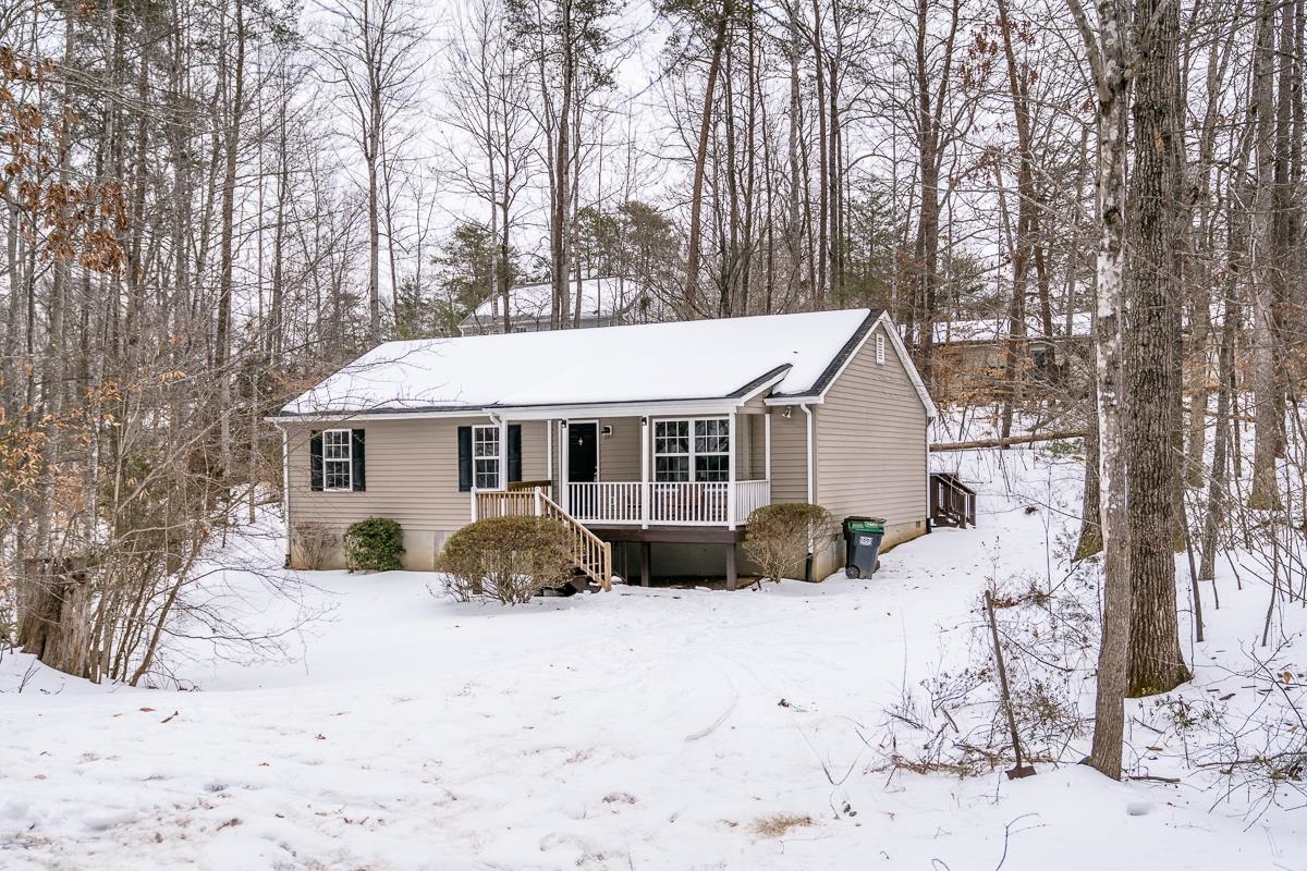 a front view of a house with a yard covered in snow