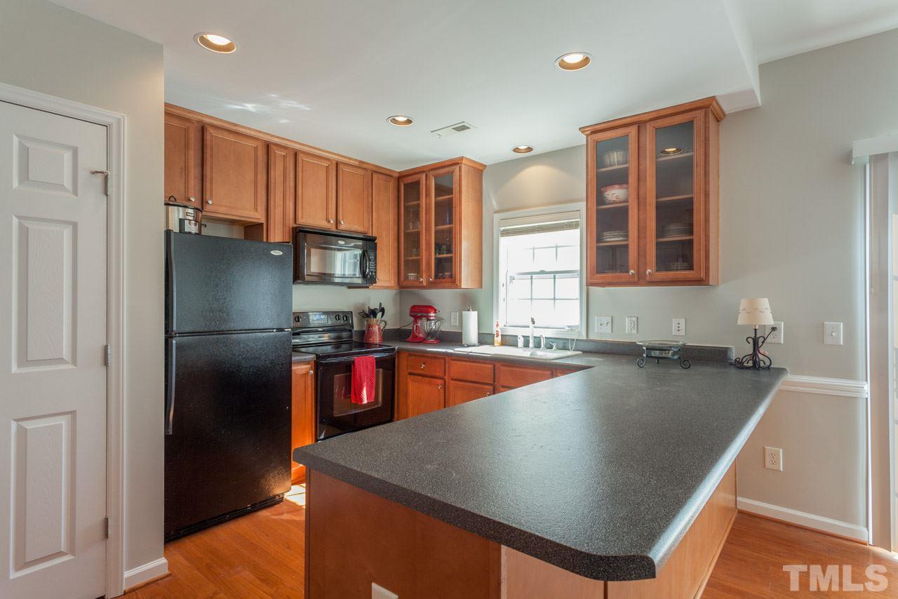 2120 Piney Brook Road, Unit 102 Raleigh, NC 27614 - Photo 11 of 24 a kitchen with stainless steel appliances granite countertop a refrigerator a sink and a stove
