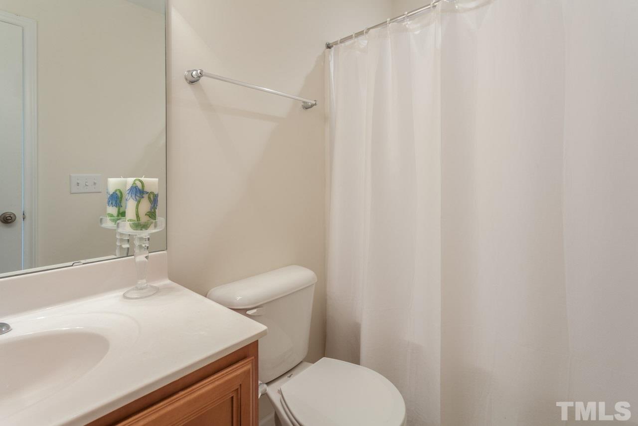2120 Piney Brook Road, Unit 102 Raleigh, NC 27614 - Photo 21 of 24 a white toilet sitting next to a bathroom sink