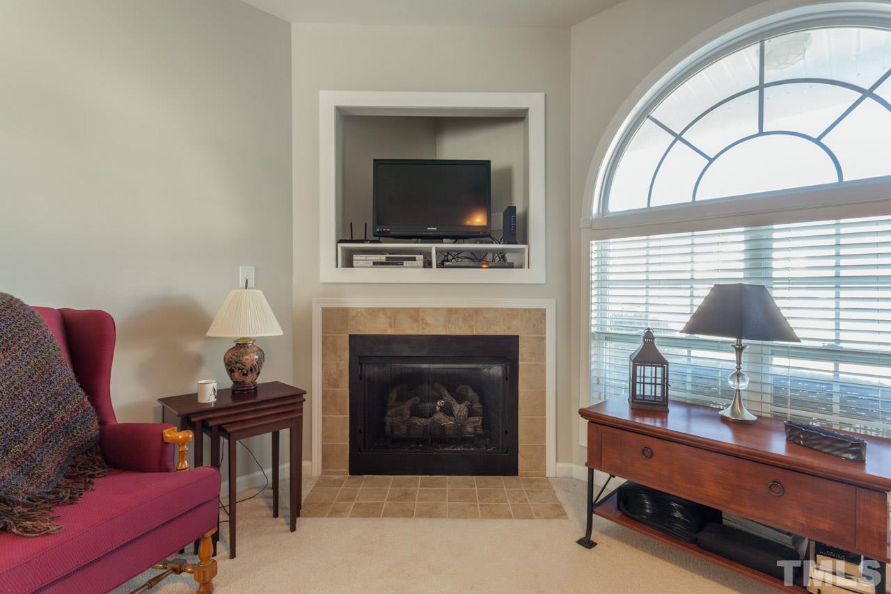 2120 Piney Brook Road, Unit 102 Raleigh, NC 27614 - Photo 8 of 24 a living room with furniture a flat screen tv and a fireplace